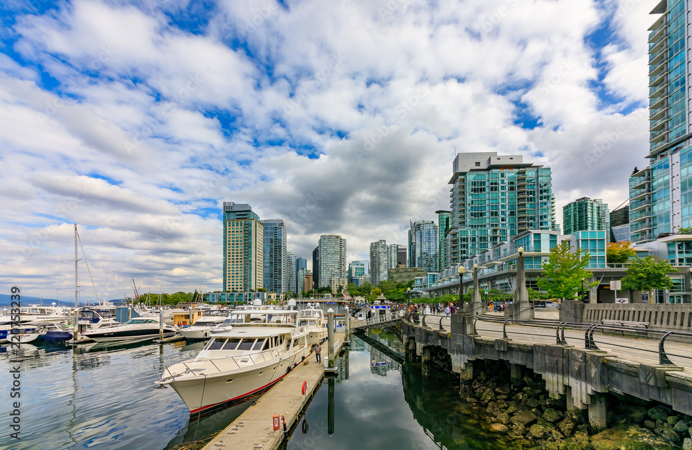 Coal Harbor in Vancouver British Columbia with downtown buildings boats and reflections in the water