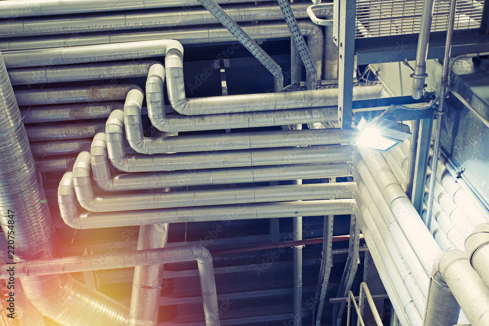 Equipment, cables and piping as found inside of a modern industrial power plant. Industrial zone, Steel pipelines, valves, cables and walkways Equipment, cables and piping as found inside of a modern industrial power plant. Industrial zone, Steel pipelines, valves, cables and walkways
