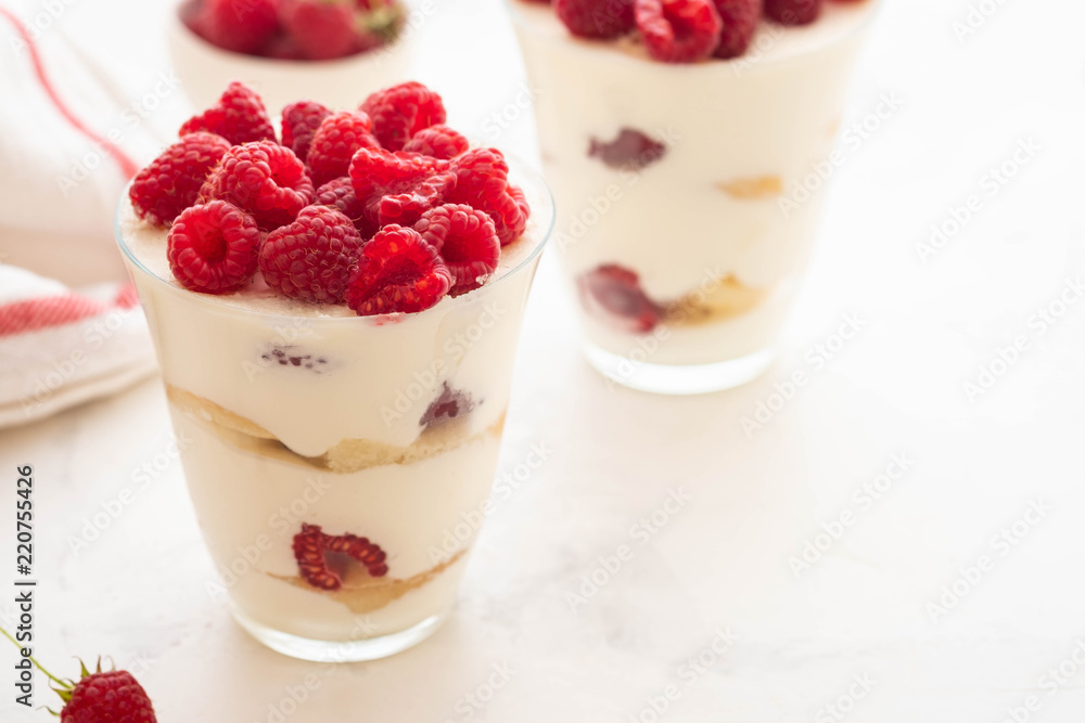 Raspberry dessert, cheesecake, raspberry tiramisu, trifle, mousse in a glass on a white background. Raspberry dessert, cheesecake, raspberry tiramisu, trifle, mousse in a glass on a white background.
