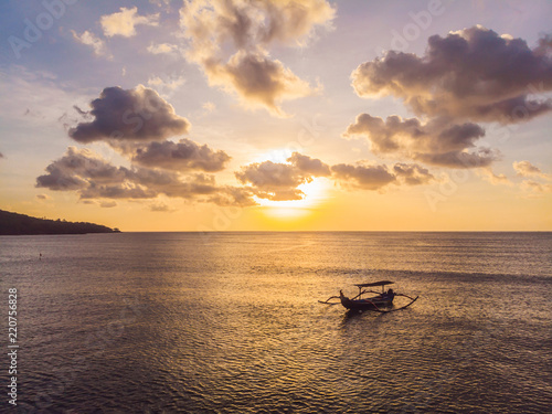 Traditional Balinese boat Jukung at Jimbaran beach at sunset in Bali, Indonesia Photo from the drone photo