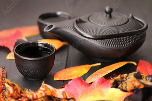 Autumn tea drinking.autumn tea mood. black teapot in Asian style and   autumn leaves on a black wooden background.	