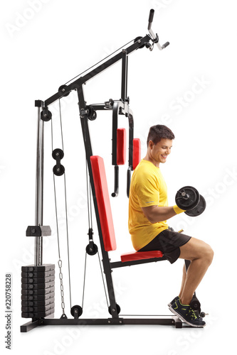 Young man exercising on a fitness machine with barbells isolated on white background