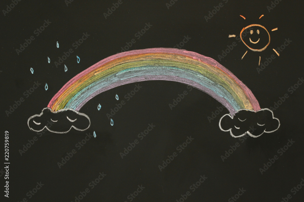 Actual drawing on black chalk board. Colorful rainbow on clouds with