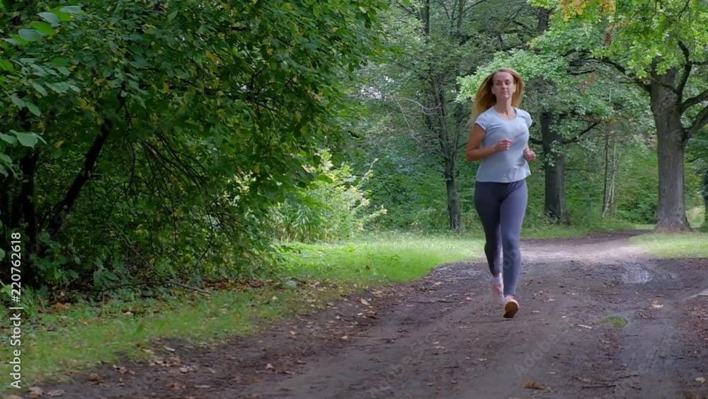 Running woman in forest at summer time, slow motion video Running woman in forest at summer time, slow motion video