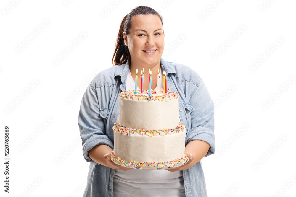 Overweight woman smiling and holding a birthday cake Overweight woman smiling and holding a birthday cake