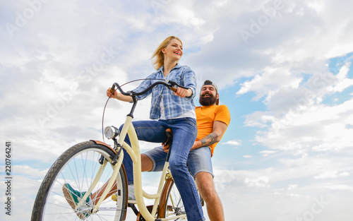 Couple in love date cycling. Couple with bicycle romantic date sky background. Let her be leader. Psychology of relationships. Leadership in family and marriage. Girl controls bicycle handlebar