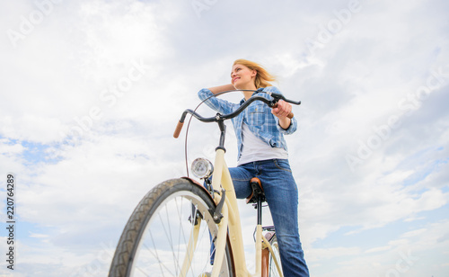 Girl rides bike sky background. Bike rental shops primarily serve people who do not have access to vehicle typically travellers and particularly tourists. Woman rent bike to explore city copy space © be free