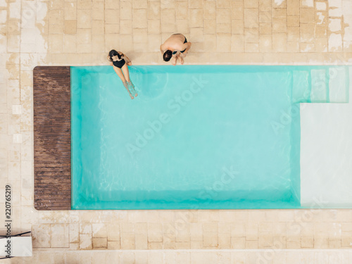 Billede på lærred top view of couple resting at poolside in Italy