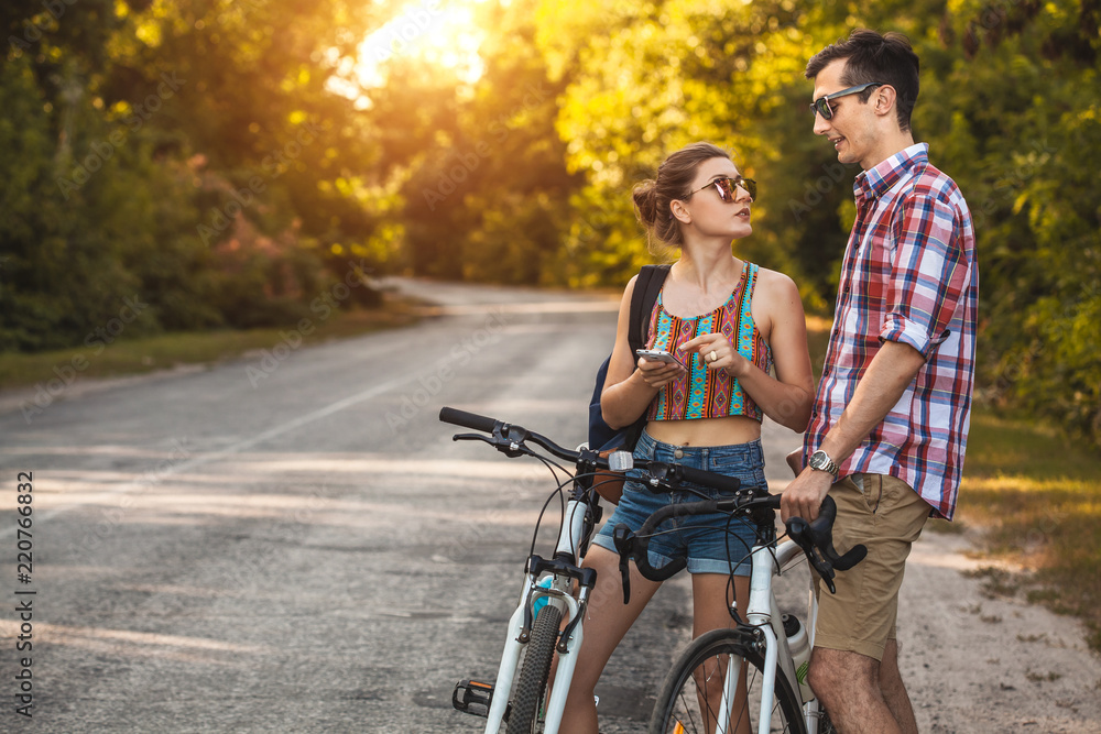 Young couple biking on a forest road in a sammer day Young couple biking on a forest road in a sammer day