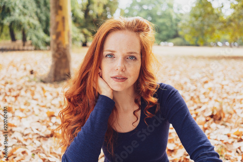Attractive young redhead woman staring pensively