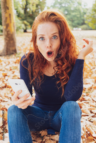 Shocked young redhead woman staring at the camera photo