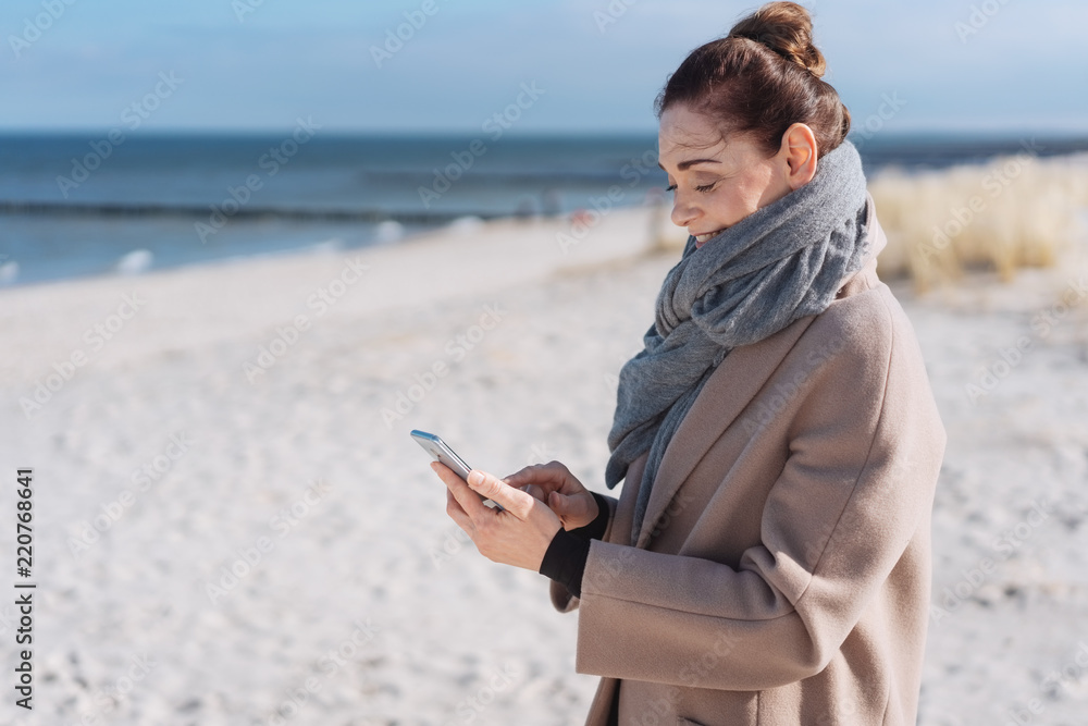 Naklejka premium Woman enjoying the winter sunshine at the beach