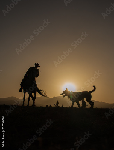 Fototapeta Naklejka Na Ścianę i Meble -  horses, cowboys, dogs at sunset