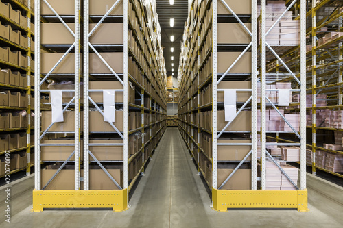 Empty narrow aisle amidst racks at distribution warehouse