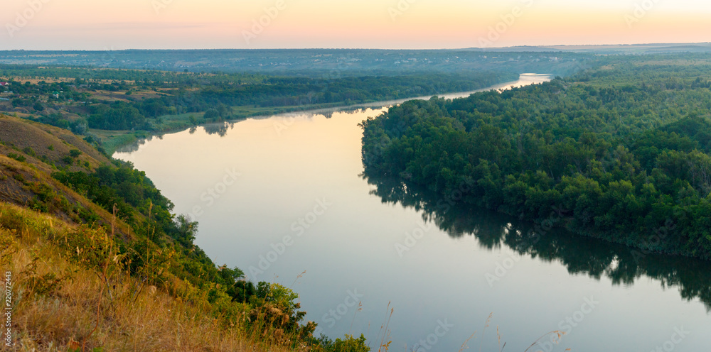 The curved line of river among forest in the dusk. Seversky Donets river, Russia