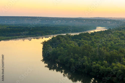 The tranquil view of river with forest on riverside in the misty dusk. Seversky Donets river  Russia