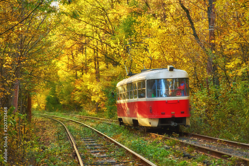 Red retro tram goes along the route