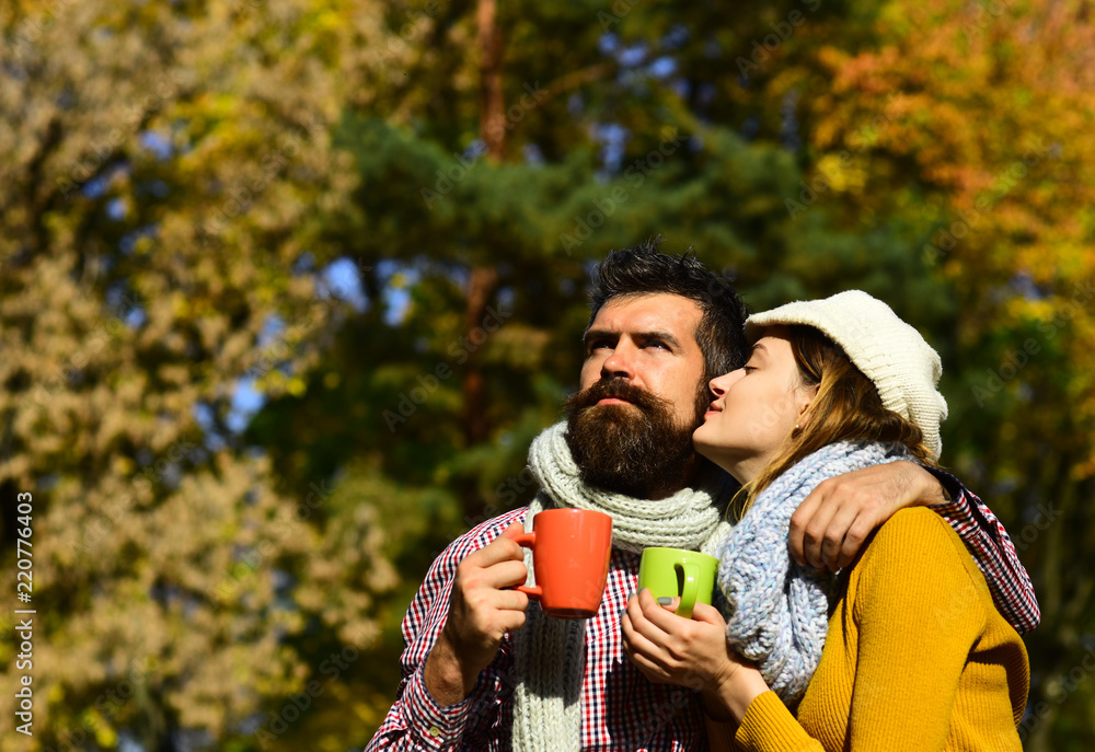 Man and woman with dreamy faces on autumn trees background