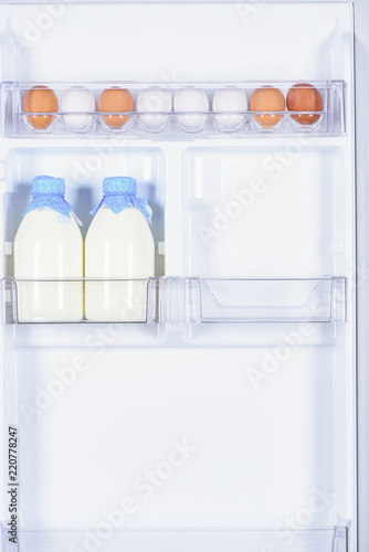 chicken eggs and bottles of milk in fridge
