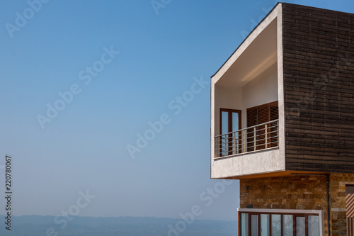 Side view of one modern penthouse apartmen with large balcony. Blue sky and horizon in the background. © Pebo