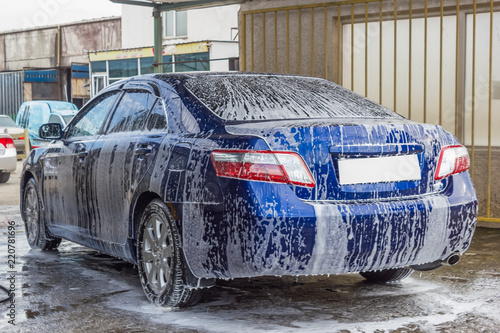 blue car in foam on car wash