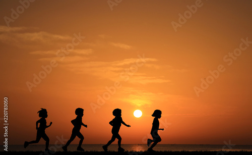 Silhouette girls running on sunset