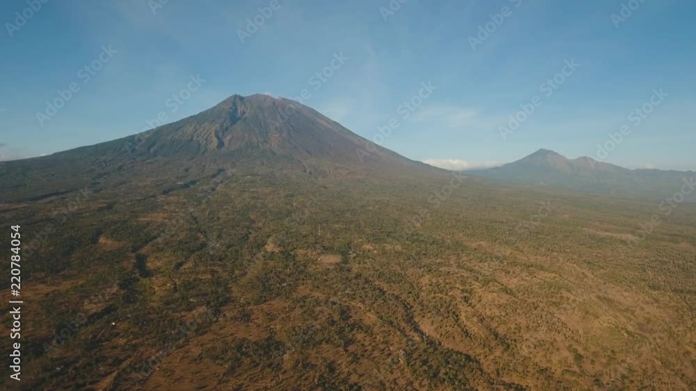 Aerial view of Volcano Mount Agung with smoke at sunrise, Bali, Indonesia. Conical volcano of Gunung Agung. Rural mountain landscape. 4K, Aerial footage. Aerial view of Volcano Mount Agung with smoke at sunrise, Bali, Indonesia. Conical volcano of Gunung Agung. Rural mountain landscape. 4K, Aerial footage.