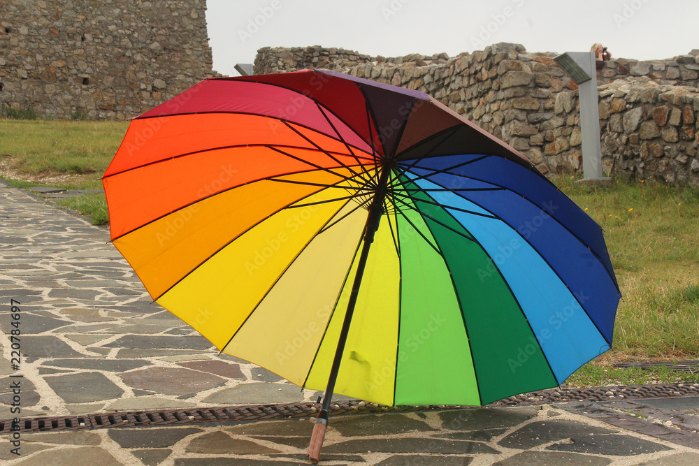 Rainbow umbrella - colourful umbrella on a pavement