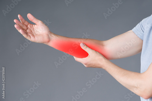 Pain in forearm, muscle inflammation, studio shot on gray background photo