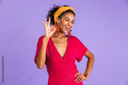 Image of cheerful happy woman 20s in hair band smiling and showing ok sign, isolated over violet background