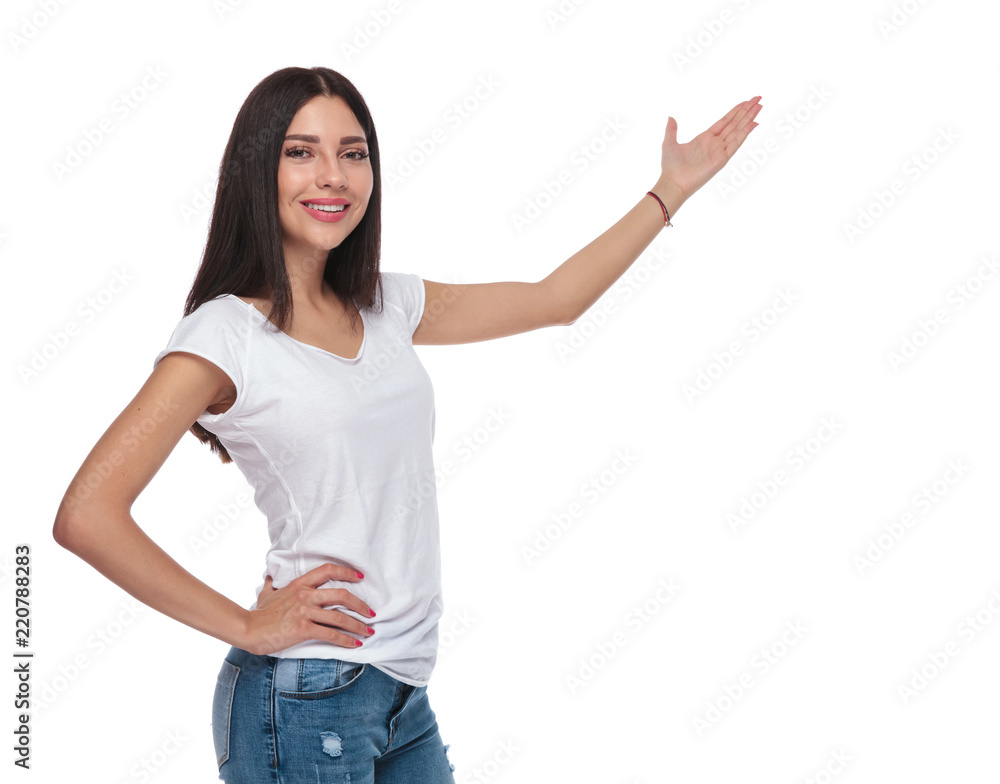 pretty brunette woman smiling and presenting to side pretty brunette woman smiling and presenting to side