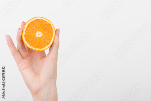  Female hands holding a lemon, orange, kiwi on a white background