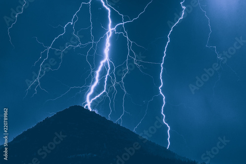 Lightning and hill. Storm in mountains
