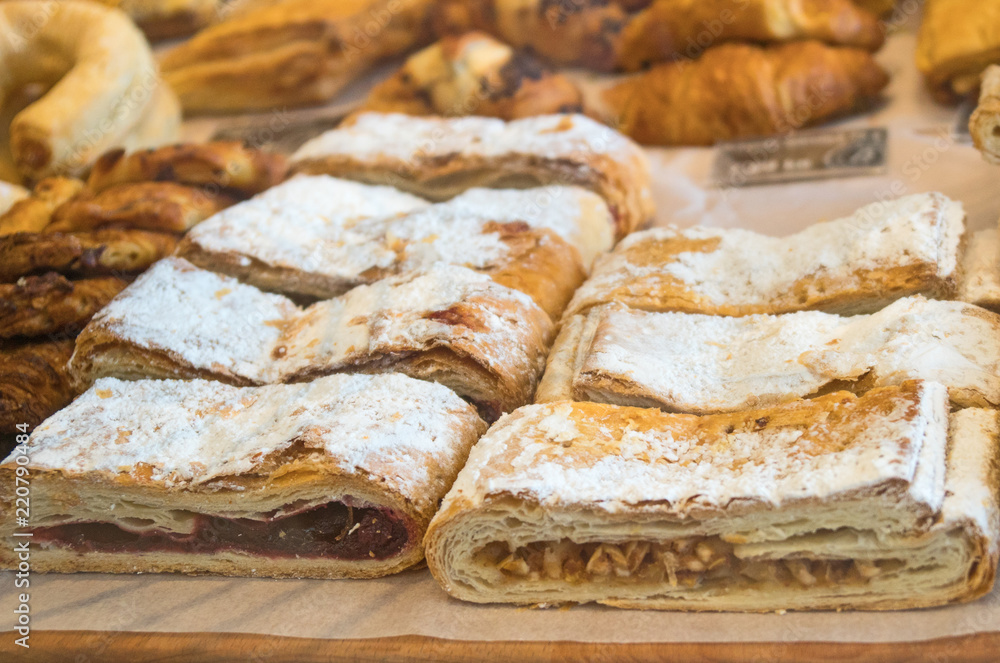 Puff cakes with cherries and apples on the market.