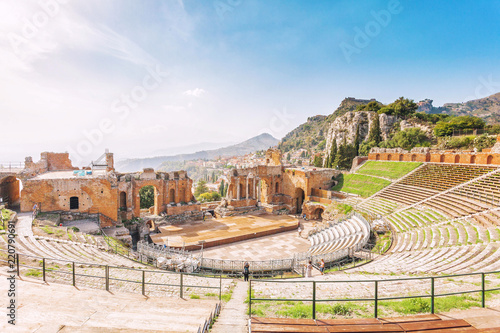 Ruins of the Greek Theater of Taormina and the picturesque mountain chain from the vulcano Etna to Castelmola in the background. Taormina, Sicily, Italy