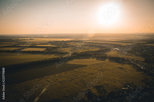 Aerial view from drone to summer rural landscape at sunset sunlight with fields and trees