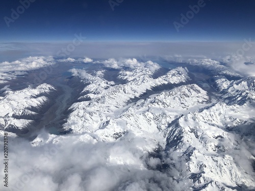 snow capped mountains and lakes in New Zealand as seen looking out of the window of a plane