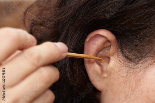 cleaning ear using wooden earpick