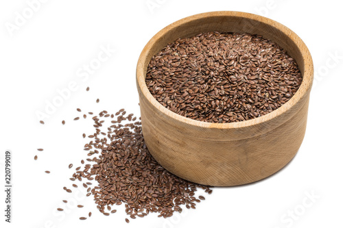 Close up of linseeds or flax seeds in a wooden bowl with small pile isolated on white background