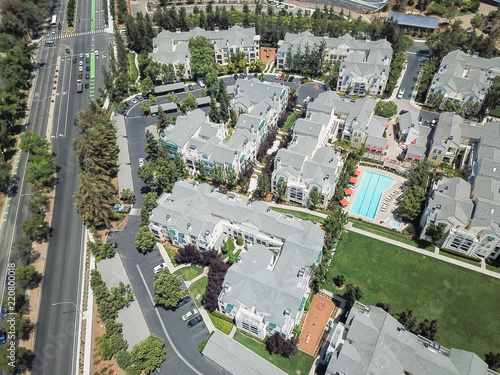 Aerial view typical multi-level apartment homes with swimming pool near freeway in Silicon Valley, California photo