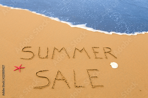 summer sale written in the sand on a sunny beach photo