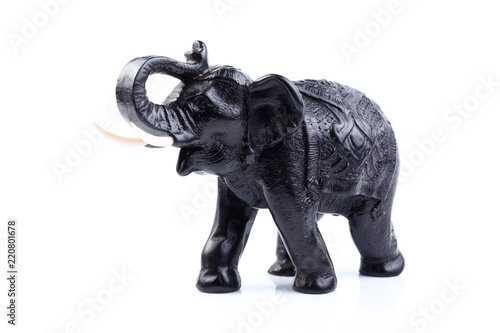 Black Engraved pattern elephant made of resin like wooden carving with white ivory. Stand on white background, Isolated, Art Model Thai Crafts, For decoration Like in the spa.