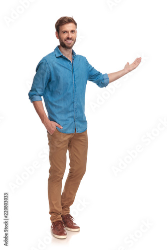 Foto full body picture of a young casual man presenting