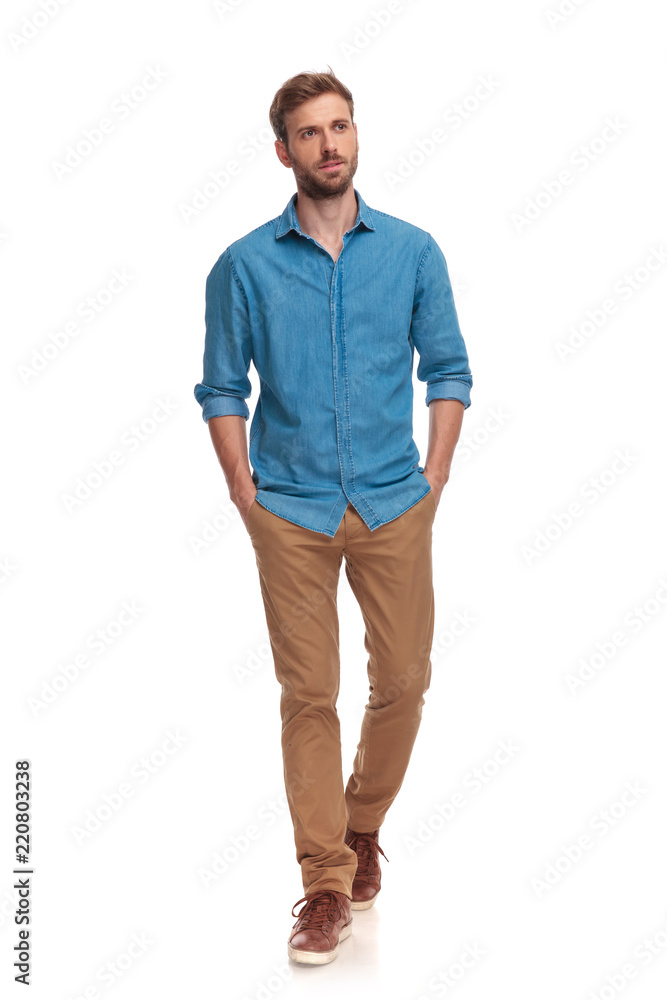 young casual man walking with hands in pockets young casual man walking with hands in pockets