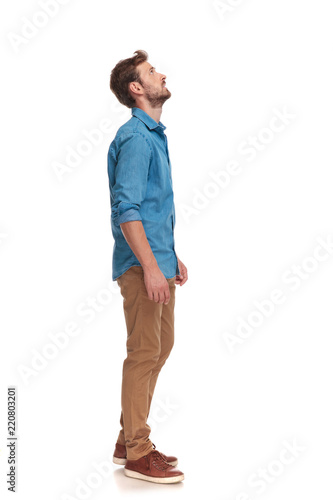 side view of a casual man looking up at something