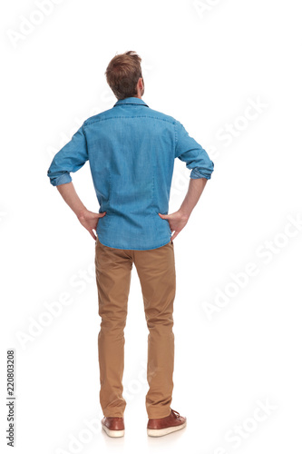 back view of a casual man with hands on waist