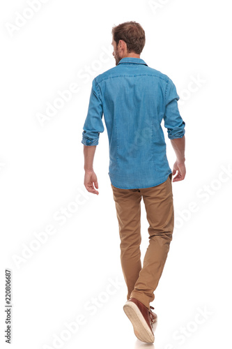 back view of  casual man walking and looking to side photo