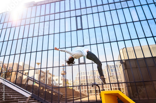 Frau macht Salto mit Spiegelung in Fenstern