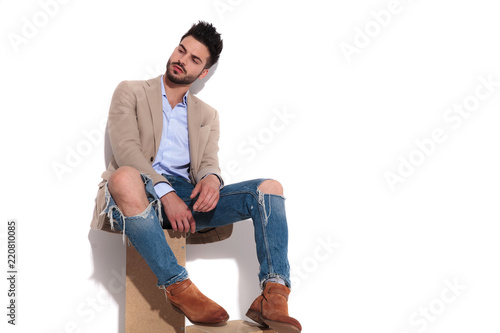 smart casual man sitting and looking down to side