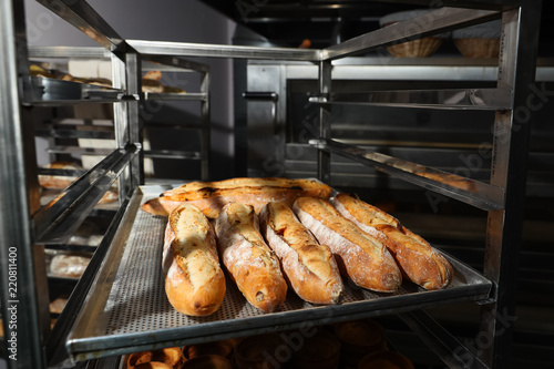 Many French baguettes on a baking sheet in the bakery